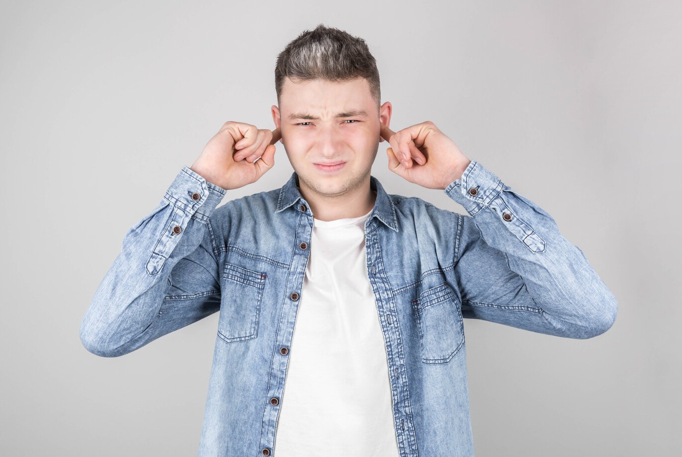 Lady with plaster on nose, doctor examining patients face after plastic surgery rsz man red home sweater plug his ears with his fingers against loud noise